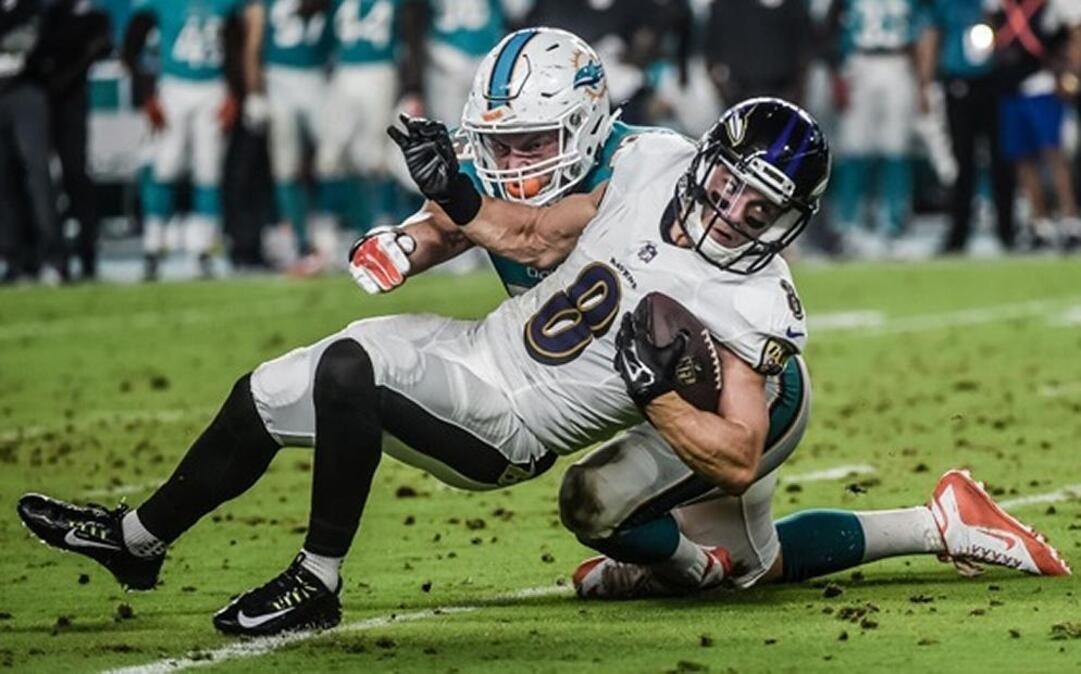 Belleville East graduate Chase Allen, an undrafted rookie hopeful with the Miami Dolphins, makes a stop on Baltimore Ravens wide receiver Griff Whalen during a preseason game Saturday. Allen led the Dolphins with 8 tackles, seven of them solos, in the loss.