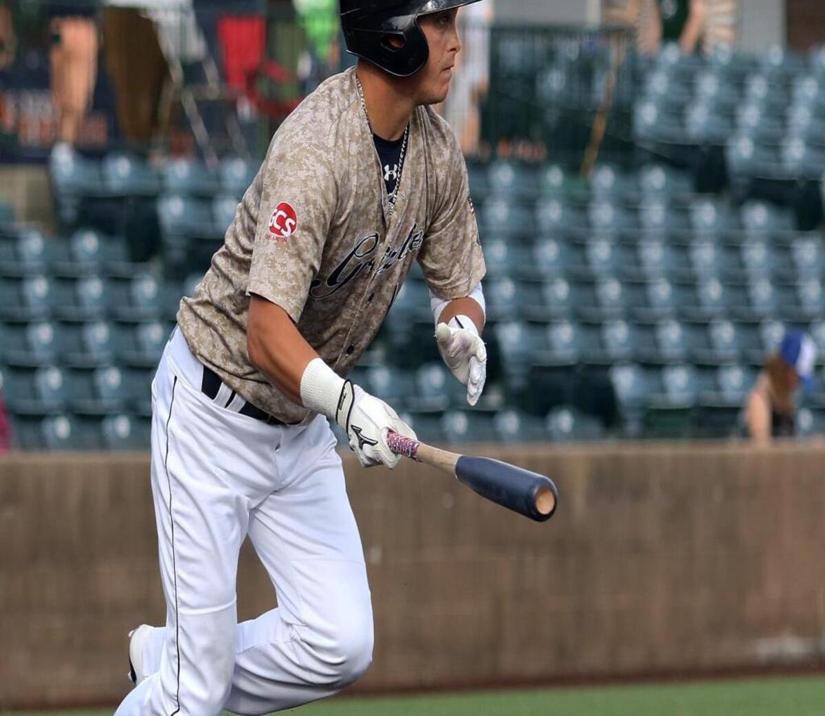 Cody Livesay of the Grizzlies singles and runs to first base in the first inning against Traverse City .