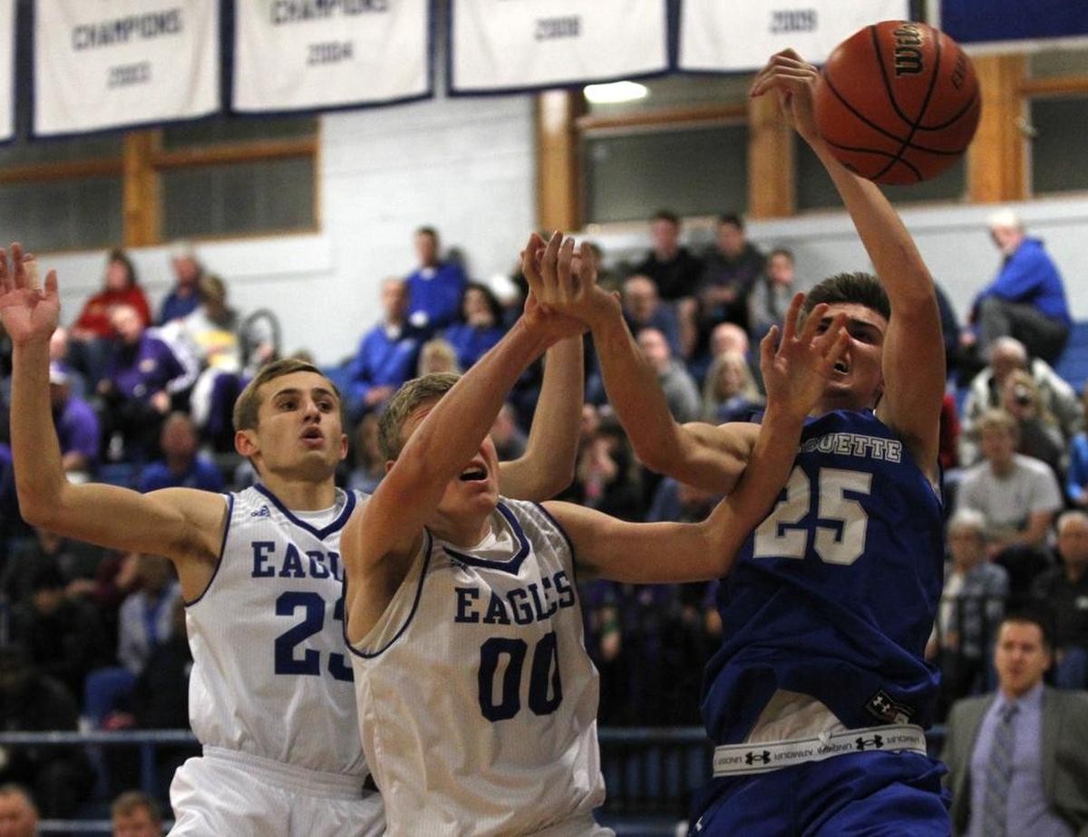 Columbia’s Jordan Holmes and Jon Peterson battle Marquette’s Jake Hall for a rebound during their game at the Freeburg Columbia Boys Holiday Basketball Tournament at Freeburg High School on Thursday.
